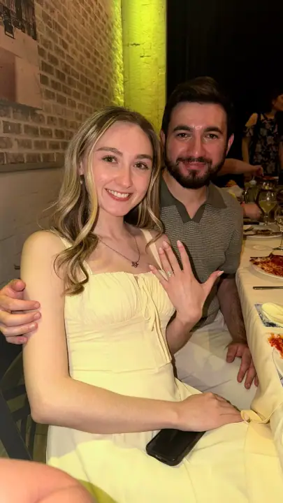 Christopher and Jacqueline smiling as Jacqueline shows her engagement ring