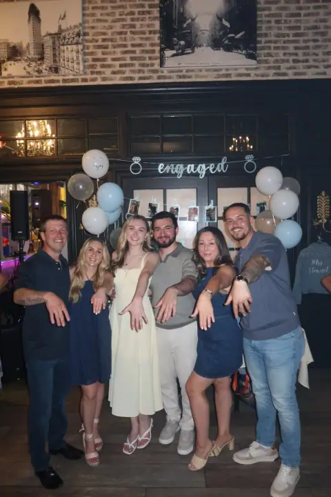Christopher and Jacqueline posing with a group of close friends