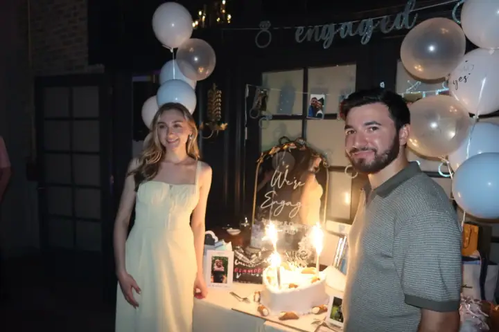 Christopher and Jacqueline beside their sparkler-lit engagement cake