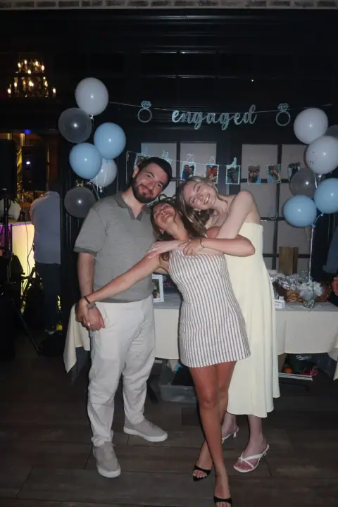 Christopher and Jacqueline leaning playfully around a friend